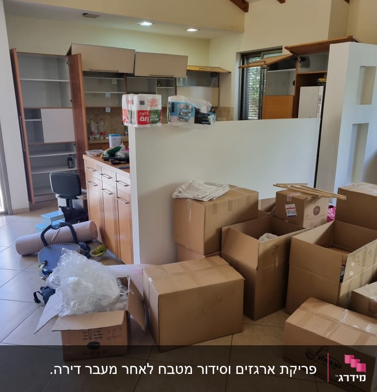 קופסאות קרטון וציוד ארוז במטבח ריק